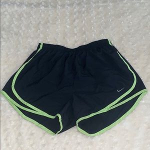 Black nike shorts with green outline.